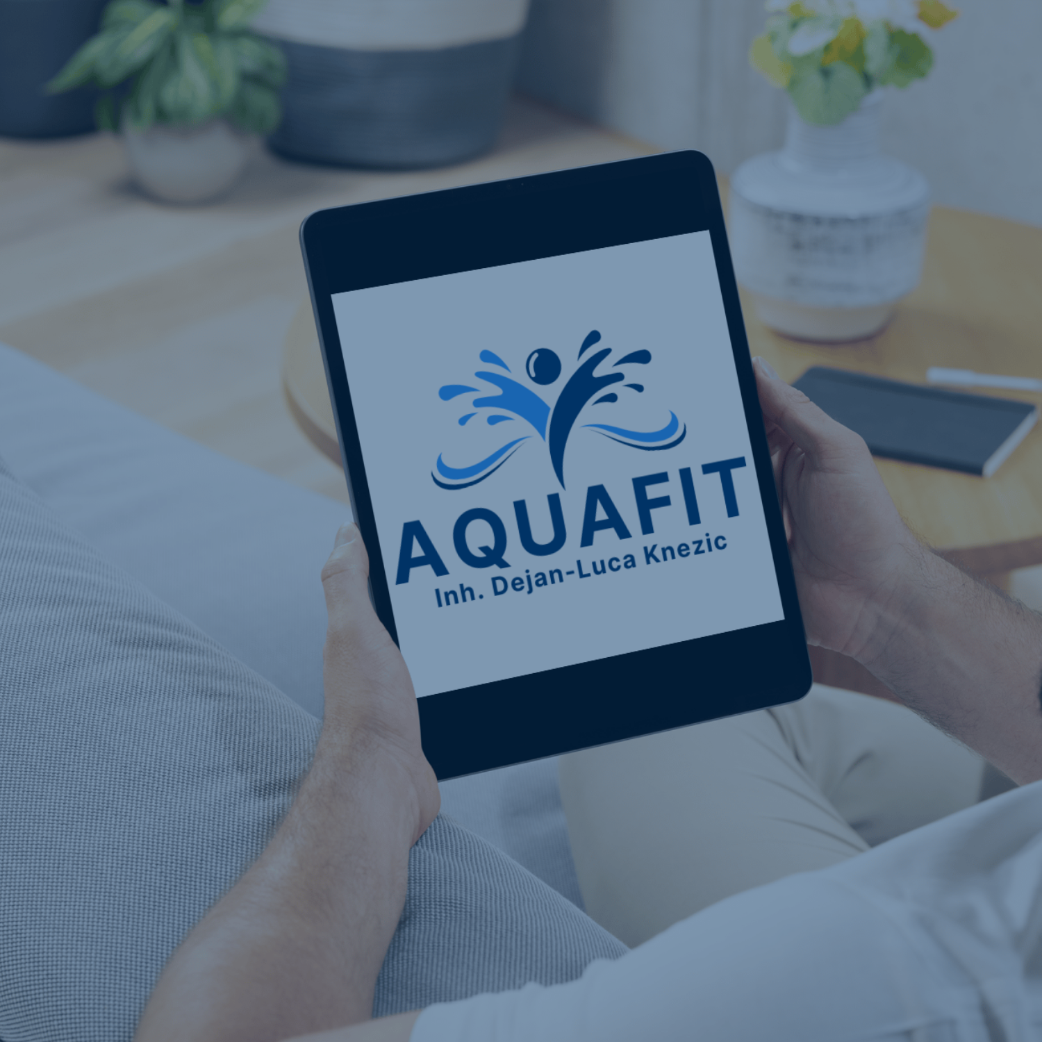 Person hält ein Tablet mit dem AquaFit-Logo – Symbol für digitale Inhalte und E-Books.