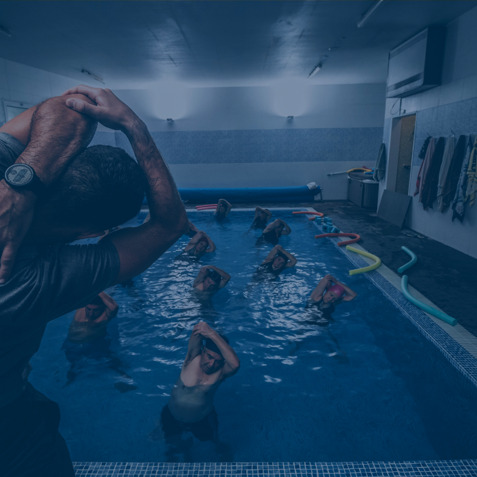 Qualifizierter Schwimmtrainer unterstützt eine Kursteilnehmerin im Becken, für persönliche Betreuung und individuellen Lernerfolg.