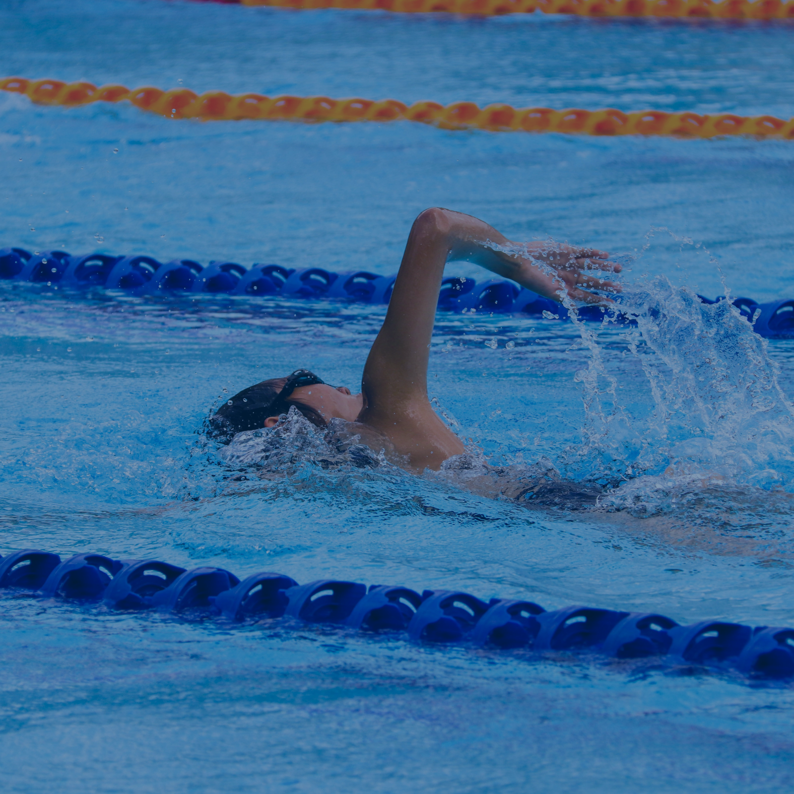 Schwimmer im Becken, der die Rückenschwimmtechnik übt – perfekt für fortgeschrittenes Schwimmtraining.