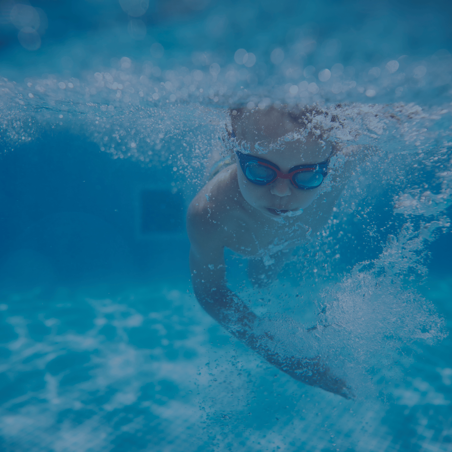 Schwimmer mit Schwimmbrille gleitet kraftvoll durch das Wasser – Expertenkurs bei AquaFit mit der Möglichkeit, das Silber- und Gold-Abzeichen zu erreichen.