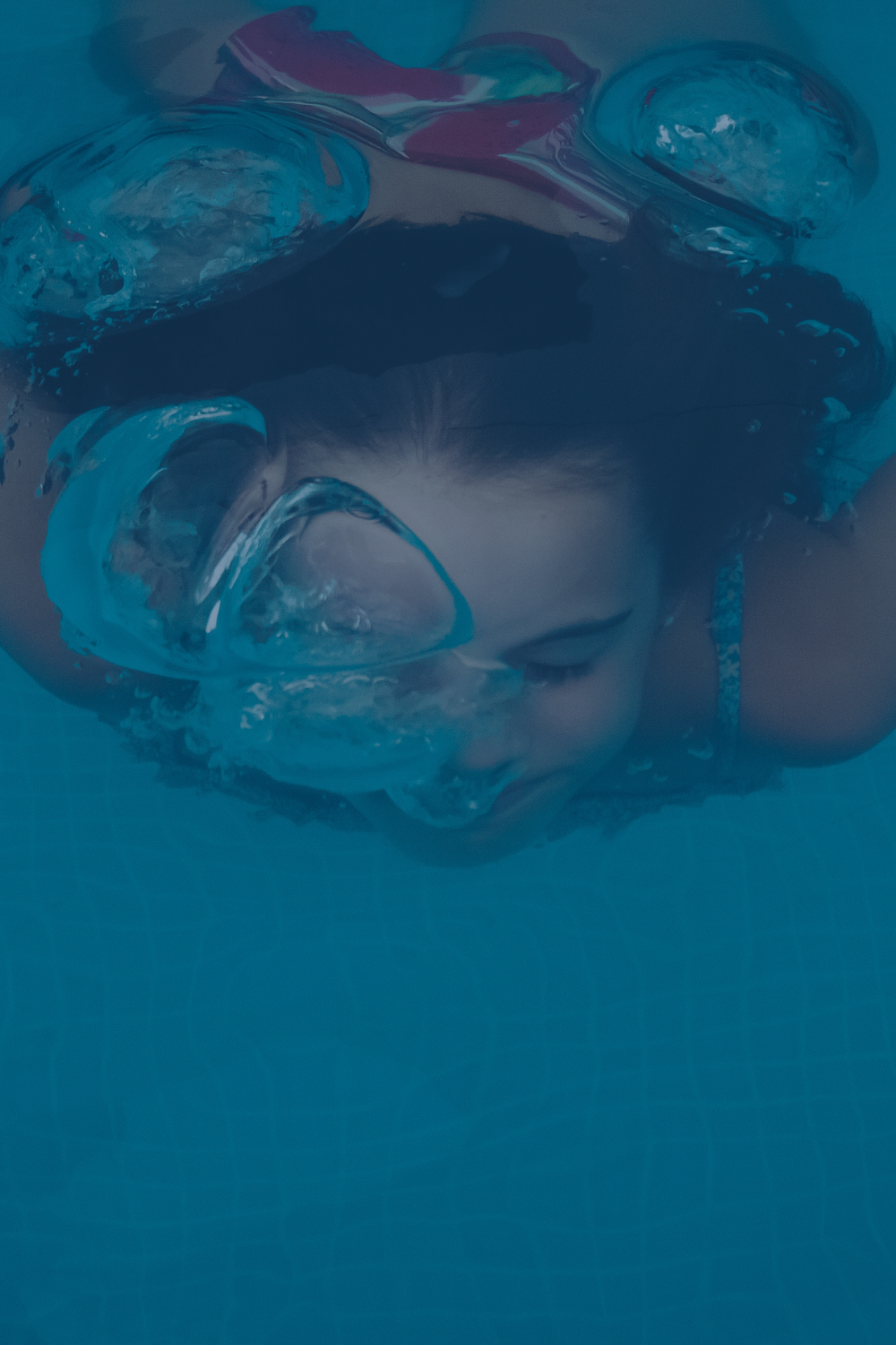 Kind taucht lächelnd unter Wasser mit Schwimmbrille – AquaFit Schwimmkurse für Kinder fördern Spaß und Sicherheit im Wasser.