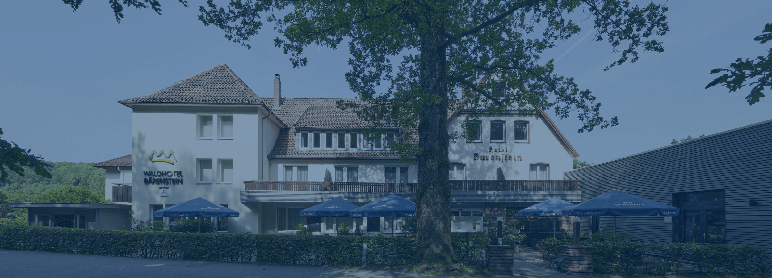 Außenansicht des Waldhotel Bärenstein, eingebettet in den Teutoburger Wald. Perfekter Ort für AquaFit-Schwimmkurse mit modernem Schwimmbad bei 30 Grad Wassertemperatur.